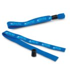 Blue fabric wristbands with a black plastic clasp are shown on a white background. The wristbands are marked with the word xenia and CONSTANT in white letters, accompanied by a white logo resembling a wave.