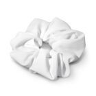 A white fabric scrunchie is placed against an off-white background. It appears soft and fluffy, showcasing its gathered and elastic shape, suitable for tying hair or as a fashion accessory.