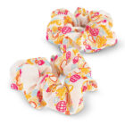 Two colorful scrunchies with abstract designs in shades of yellow, pink, and orange. The fabric appears soft and ruffled, adding texture to the hair accessories. They are placed against a white background.