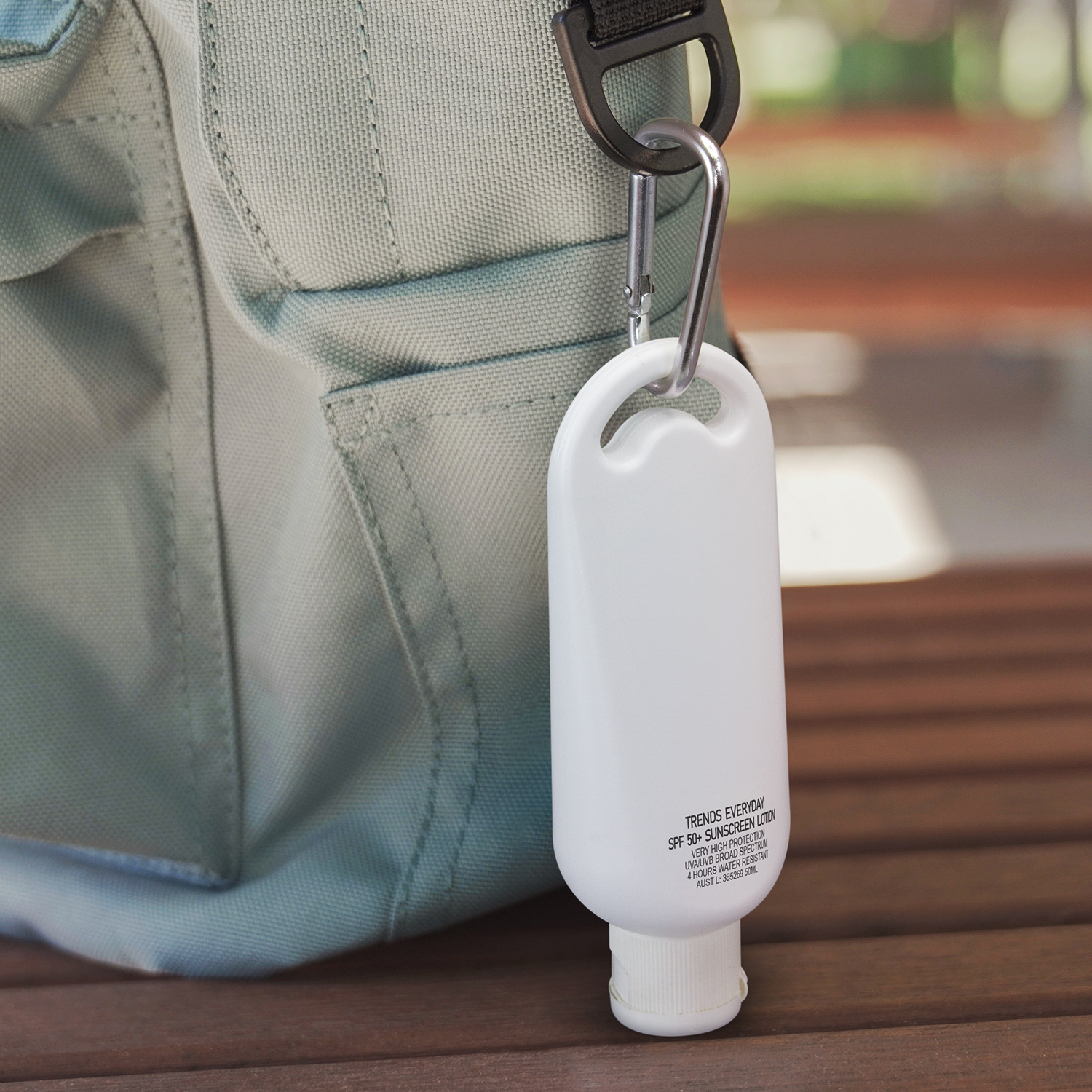 TGA-certified sunscreen bottle clipped to a light bags strap with a carabiner.