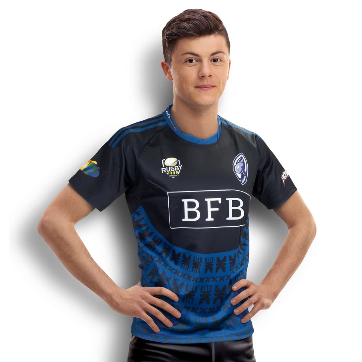 A person wearing a blue and black sports jersey with various logos, including ones labeled Rugby Rugby and BFB. The jersey features a patterned design, and the person stands with hands on hips, smiling at the camera.