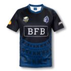 A navy blue and black rugby jersey featuring various logos, including RUGBY and BFB. The shirt has a tribal pattern on the lower half and additional sponsor logos on the sleeves.