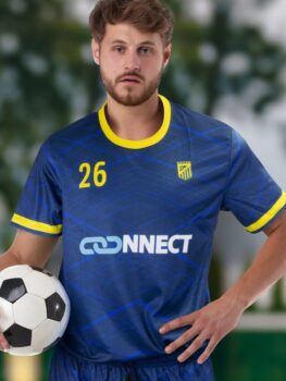 A soccer player in a blue and yellow team jersey holds a soccer ball.