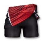 Black shorts featuring a red and black asymmetrical panel design on one side, with diagonal stripes and white accents. The panel is partially draped, creating a layered look.