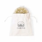 A brush in a drawstring bag with a cabin logo and trees.