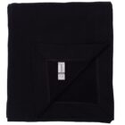 A folded black blanket with a visible care label on one corner.