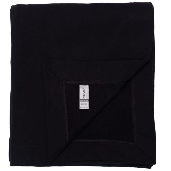 Folded black towel with a visible care label on one corner against a white background.