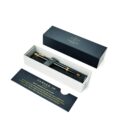 Black and gold Parker pen in an open gift box with a card beside it on a white background.