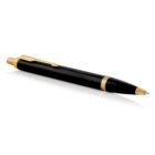 Black and gold ballpoint pen lying on a white surface.