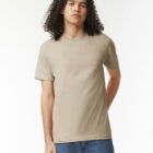 Person with curly hair wearing a beige t-shirt and blue jeans against a white background.
