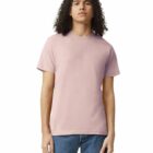 Person with long curly hair wearing a light pink t-shirt and blue jeans, standing facing forward.