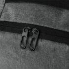 Close-up of a gray backpack with black zipper and dual zipper pulls.
