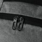 Close-up of a black double zipper on a gray fabric backpack.