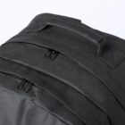Close-up of a black backpack with three zippers and carrying handle.