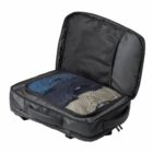 Open black suitcase with clothes neatly packed inside.