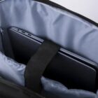 Laptop inside a padded bag compartment with a securing strap.