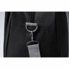 Close-up of a black bags side with a metal ring and attached gray strap.