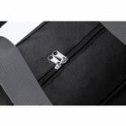 Close-up of a black fabric bag with silver zippers and gray strap.