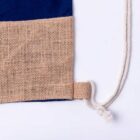 Close-up of a blue and burlap drawstring bag with a white rope handle.
