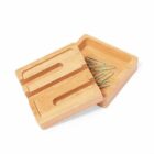 Square wooden box with a sliding lid, containing paperclips.