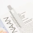 Metal ruler bookmark on an open cookbook page titled NAAN.
