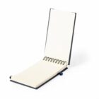 Spiral-bound notebook open on a plain page, standing upright on a white background.