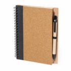 Spiral-bound notebook with a cork cover and a pen in the holder.