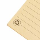Close-up of lined paper corner with a recycling symbol.
