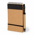 Small spiral notebook with pen attached, featuring a brown cover and black band.