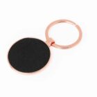 A round, black and gold keychain on a white background.