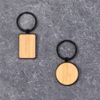 Two wooden keychains, one rectangular and one circular, on a textured gray surface.