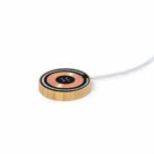 Gold and black wireless charging pad with a cable on a white background.