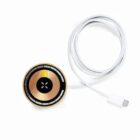 Round metallic charging pad with a connected white cable and USB-C plug.