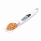 A digital spoon scale with grains on the scoop.