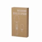 Box of a weighing scales spoon on a white background.
