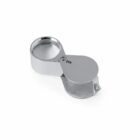 Silver jewelers loupe with 20X marking, folded partially open.