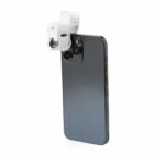Smartphone with a white lens attachment clipped over its camera.