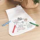 A Christmas stocking coloring page with crayons, featuring festive outlines and Merry Christmas.