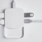 White electronic charging device with multiple USB cables connected.