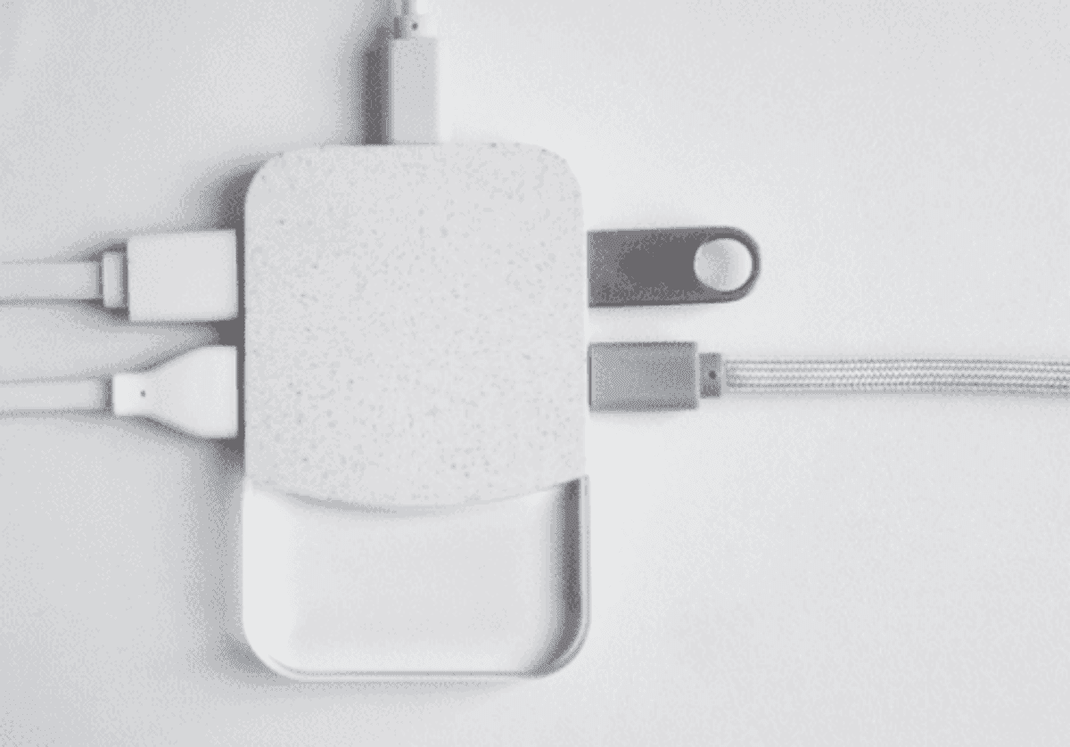 White electronic charging device with multiple USB cables connected.