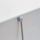 Close-up of a corner bracket securing a thin metal rod to a board.