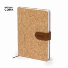 A journal with a natural cork cover and a brown leather strap embossed with 2025. It has a ribbon bookmark. The cover texture is visible, and NATURAL CORK is printed in the top left corner.