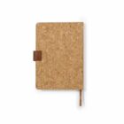 A closed notebook with a cork cover, featuring rounded corners. It has a brown pen holder on the left side and a matching brown ribbon bookmark hanging from the bottom. The notebook is centered on a white background.