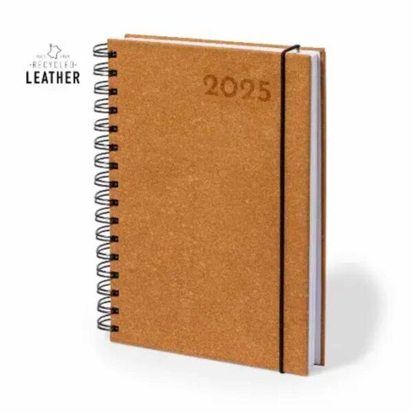 A spiral-bound notebook with a cork-textured cover, featuring 2025 embossed on the front. The notebook is secured with a black elastic band. The cover is made of recycled leather, as indicated by the text in the top left corner.
