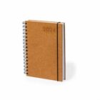 A spiral-bound notebook with a cork cover, embossed with 2024 in the top right corner. The notebook is held closed by a black elastic band.
