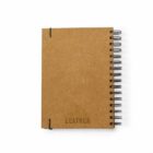 A brown spiral-bound notebook with a textured cover, embossed with the words RECYCLED LEATHER and an outline of a dogs head. The cover has two small black elastic bands securing the corners.