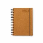 A spiral-bound notebook with a brown cardboard cover. The year 2024 is embossed in the top right corner. An elastic band holds it closed.