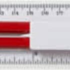 A ruler with a sharpener, eraser, and two red pencils placed inside its packaging.