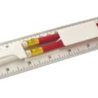 A white ruler holding two red pencils and a white pencil sharpener.