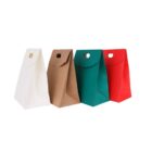 Four colorful paper gift bags in white, brown, green, and red, stand against a white background.